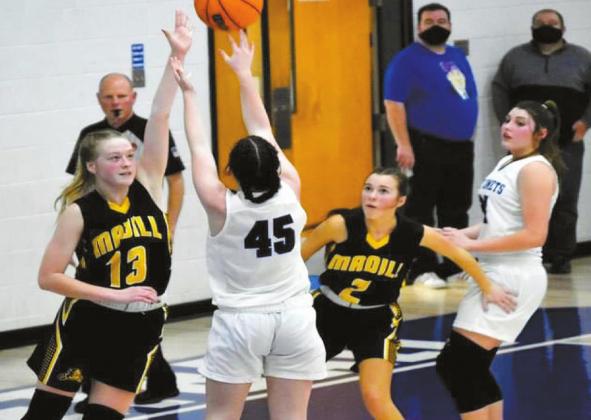 Taren Greathouse Braylee Schneider, #13, attempts to block a shot, while Jayden Weiberg, #2, blocks out any interference during the Madill v. Comets game on Friday, December 18, 2020.
