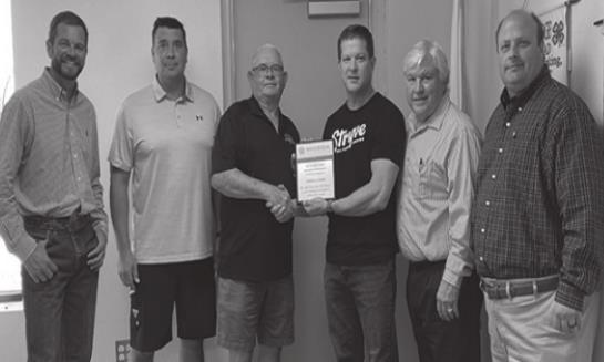 Cody Bradshaw, B.J. Bellentini, Ronald Jackson, Robert Holliday, and Travis Williams present a plaque of appreciation to Warren Pala of Stryve Foods. Summer Bryant • The Madill Record