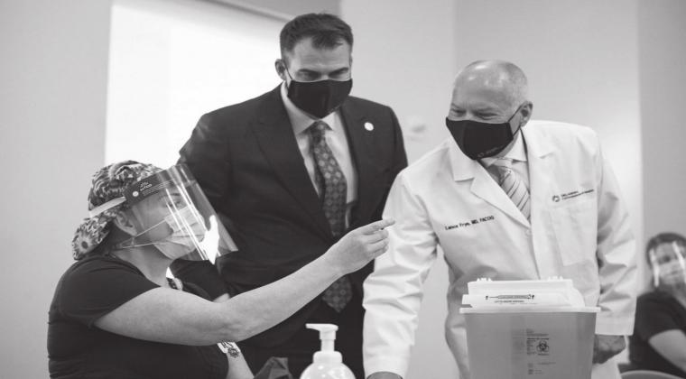ICU nurse Erica Arrocha shows Gov. Kevin Stitt and Oklahoma State Commissioner of Health Dr. Lance Frye before adminstering the state’s first COVID-19 vaccine at Integris Baptist Medical Center in Oklahoma City on Dec. 14, 2020. Whitney Bryen • Oklahoma Watch