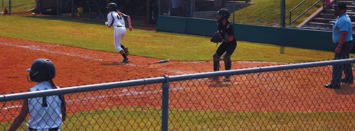 Junior Krislyn Anderson, #15 heads to first base while junior Brayleigh Thompson, #1, warms up during the Madill v. Valliant game. James Bowser •The Madill Record