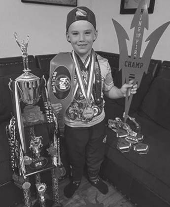 Maverick Frazier poses with more than 30 wrestling awards he has earned in recent competitions. Courtesy photo