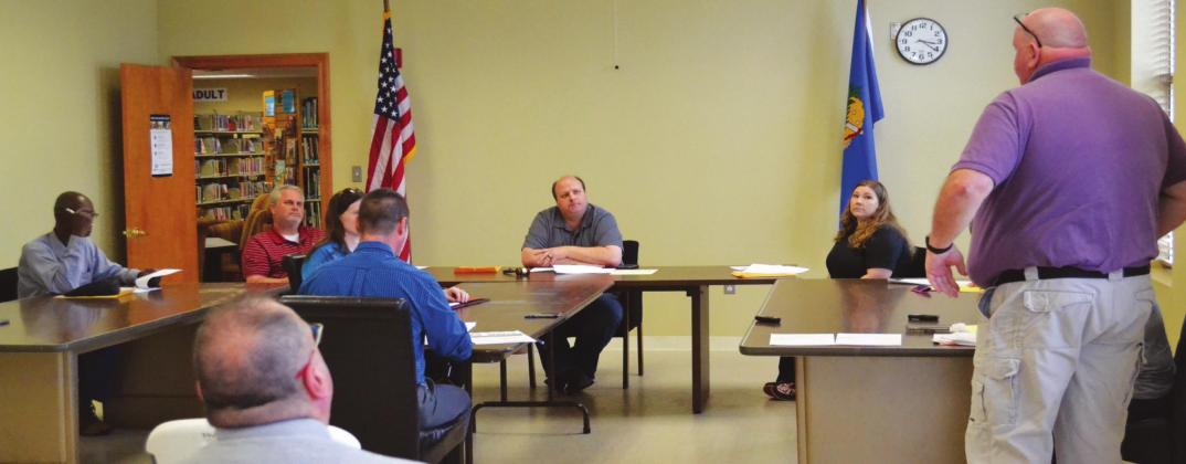 Madill emergency manager Donny Raley (far right) speaks to members of the Madill City Council at an emergency council meeting March 18. The council and staff practiced social distancing by spacing all chairs multiple feet apart. Matt Caban •The Madill Record