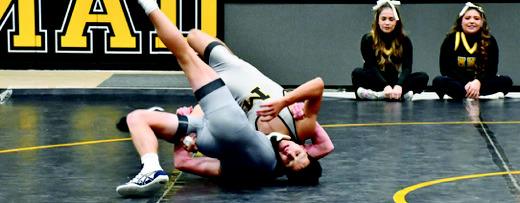 Top photo: Brandon Valles wrestles hard. Bottom photo: Kaydence Bourland kicks out of a pin. Courtesy photos