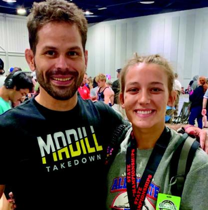 GageVaughnafterwinninghergoldmedalandqualifying for Junior Nationals stands with Coach Peter Hammer. Courtesy photo