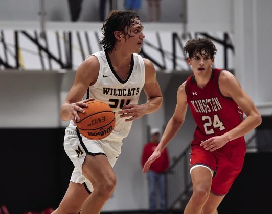 Ethan Wilkerson dribbles down the court while Reid Cason tries to stop him during the Kingston v Madill game on December 6. Crocket Uber