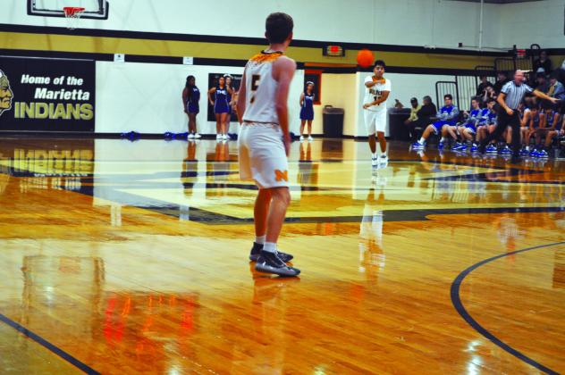 Sophmore Ezekiel Fuentes passes the ball to Senior Aron Vann during the Marietta Tournament. The Madill Boys Basketball beat the Turner Falcons.