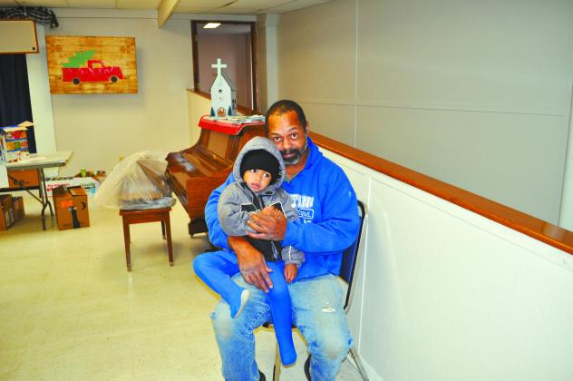 A local man and child wait for their groceries from Santa’s Elves.