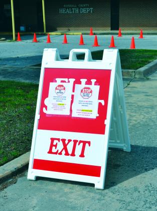 A sign sits the parking lot of the Marshall County Health Department on April 7. It advised patients to not enter until they have been screened. Photo by Matt Caban - The Madill Record