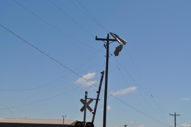 A piece of sheet metal dangles from a telephone pole as if it were a piece of cloth. Damage from the tornado on April 22 hit the area near Smiley Road hard. Photos by Charles White