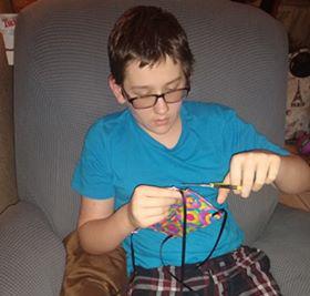 Christina Reddish's son Thomas assists her while she makes masks for people. Courtesy photo
