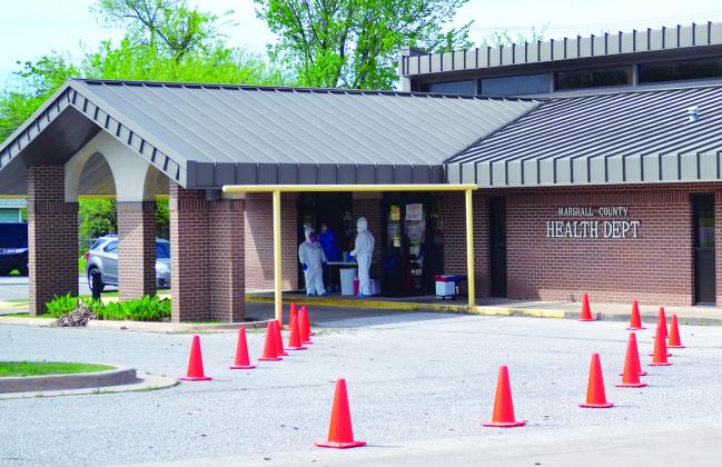 Nurses Juana Diad (left) and Lecia Tiller (right) with the Marshall County Health Department wait for a patient to arrive April 7 for COVID-19 screening and testing. They both used full personal protective equipment when dealing directly with patients. Photo by Matt Caban - The Madill Record