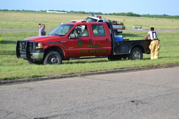 Members of the Madill Fire Department and their truck parked on a stretch of Highway 377 close to where a person was killed during a tornado April 22. Photo by Matt Caban