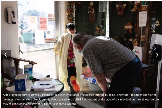 A door greeter sprays Dayna Jordan’s shoes with Lysol after she comes into the building. Every staff member and visitor receives a temperature check, survey about possible COVID-19 symptoms and a coat of disinfectant on their shoes before they’re ushered inside. (Whitney Bryen/Oklahoma Watch)