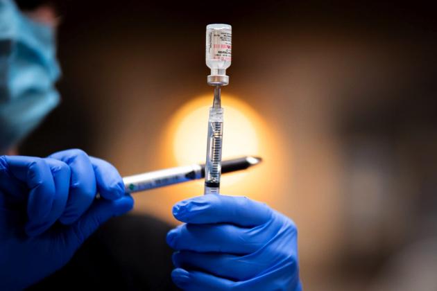 A health care worker fills a syringe with the COVID-19 Pfizer vaccine. (Whitney Bryen/Oklahoma Watch)