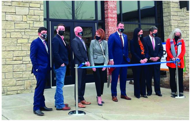 Oklahoma Gov. Kevin Stitt, center holding scissors, and state cabinet secretaries pose during a Jan. 21 ribbon-cutting ceremony at the newly relocated state Public Health Lab in Stillwater. (Oklahoma State Department of Health) 