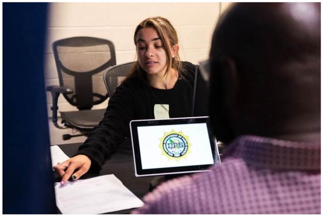 Bashaier Mahmoud, a local singer, is working as a driver’s license clerk at the Oklahoma City Department of Public Safety temporary mega center, which is dealing with a backlog following the introduction of the state’s new Real IDs. Gov. Kevin Stitt said one priority for new federal COVID-19 recovery funds is to create “best in class” customer experience with a human-centered, mobile-first interface for government services.(Whitney Bryen/Oklahoma Watch)