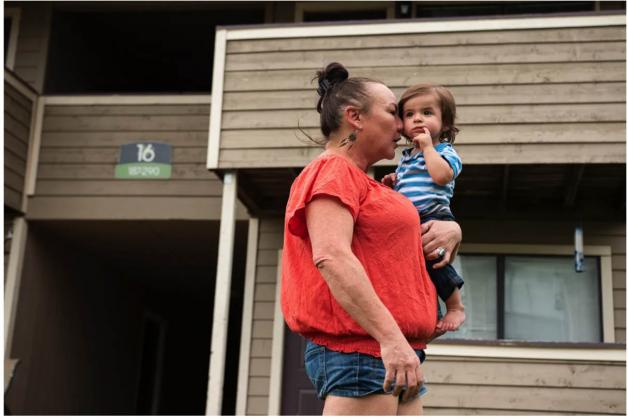 Debi Jacks takes a deep breath as she presses her face into her grandson outside of her Oklahoma City apartment. Jacks has struggled to find work for more than 18 months. She said her anxiety and depression have increased since the pandemic and with every passing week that she remains jobless. Her grandson's laugh and knowing she has two daughters to care for are the only things keeping her going. (Whitney Bryen/Oklahoma Watch)