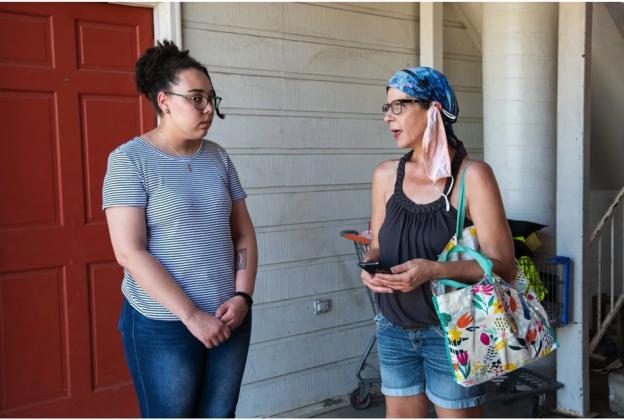 Reporter Rebecca Najera, left, interviews tenant rights advocate Terra Atkins at an apartment complex in east Tulsa. (Whitney Bryen/Oklahoma Watch)