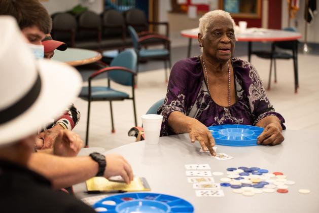 Air Force veteran Martha Higgins slides her winning card across the table during a poker tournament at the Norman Veteran Center. Last fall, residents like Higgins were on lockdown, unable to leave their rooms and interact with other residents or visitors as part of the facility's COVID-19 safety protocols. Higgins said those were "dark days." Now, with 98% of residents vaccinated, activities at the center have resumed. (Whitney Bryen/Oklahoma Watch)