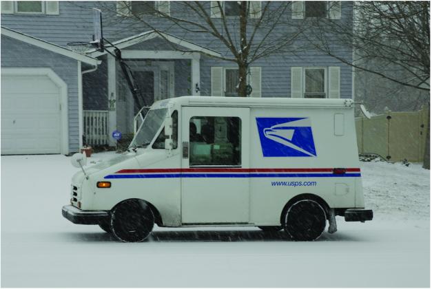 A USPS truck delivers mail in a snowstorm. (Shutterstock) (OtherWords)