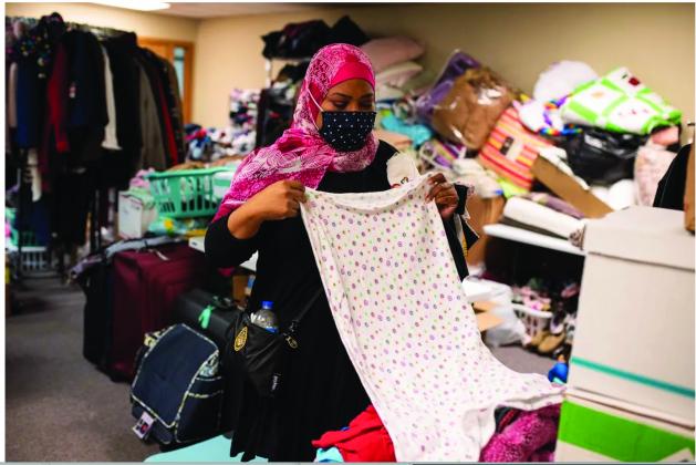 Oklahoma City resident Bobbi Elkamely folded and sorted clothing donated to refugees from Afghanistan who are resettling in Oklahoma at the Council on American-Islamic Relations last month. Elkamely said she and her children have faced ridicule because they are Muslim, which spurred her to do something to help the Afghan families coming to Oklahoma. (Whitney Bryen/Oklahoma Watch)