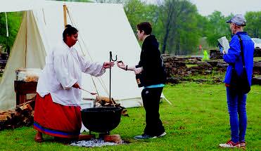 A First American woman shares a sample of pashofa — a traditional Chickasaw dish — to visitors during the 2019 Fur Trade Era Rendezvous at Fort Washita. The 2023 Rendezvous will show participants what life was like in early American history. Courtesy photo