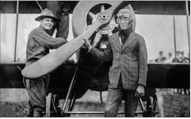 Overton Bounds holding onto the propeller of his custom made biplane. Photo courtesy of the Library of Congress