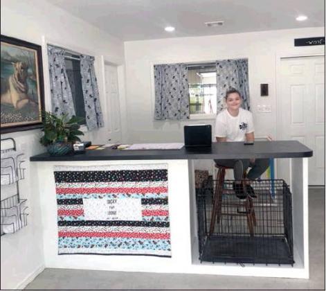 Courtesy photo • Lucky Pup Lodge Zoie Garrett, employee of Lucky Pup Lodge, sits at the front desk. The lodge is owned by Jed and Kim Hoppers.