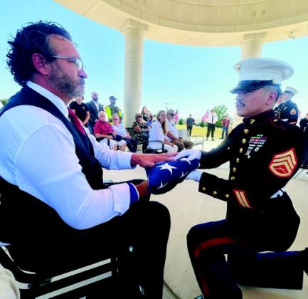 Representative Josh Cantrell receives the flag for the seven fallen soldiers. Courtesy photo