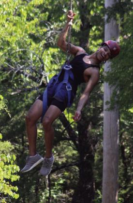 Derrick King laughs while hanging from the rope course. Courtesy photo