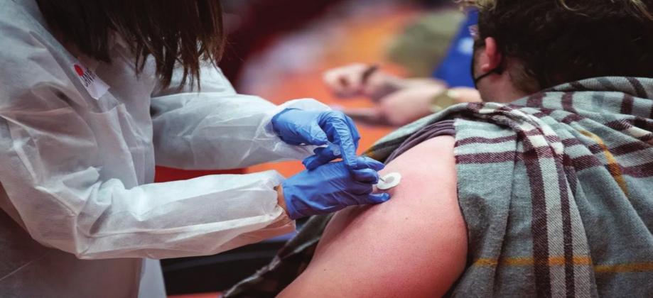 Janene Stewart, director of operations at Norman Regional Hospital, administers a COVID-19 vaccine in Norman on Feb. 22, 2021, the day teachers and adults with comorbidities became eligible to receive the vaccines. Whitney Bryen • Oklahoma Watch