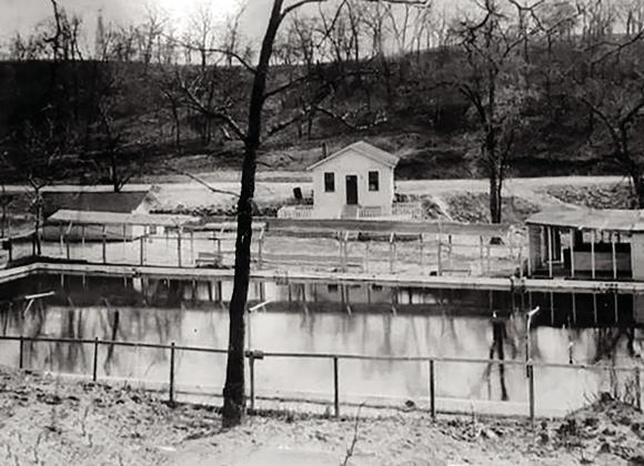 The Pettijohn Springs pool with the bathhouse on right. It's the backside of service station in the middle and confectionary in the left background with the new concrete highway is past the service station. Courtesy photo