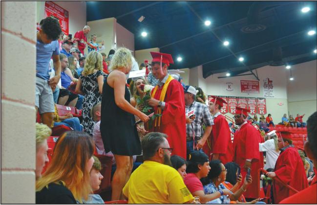 A Kingston graduate gives a white rose to his mom at the KHS Commencement on June 5. Matt Caban • The Madill Record