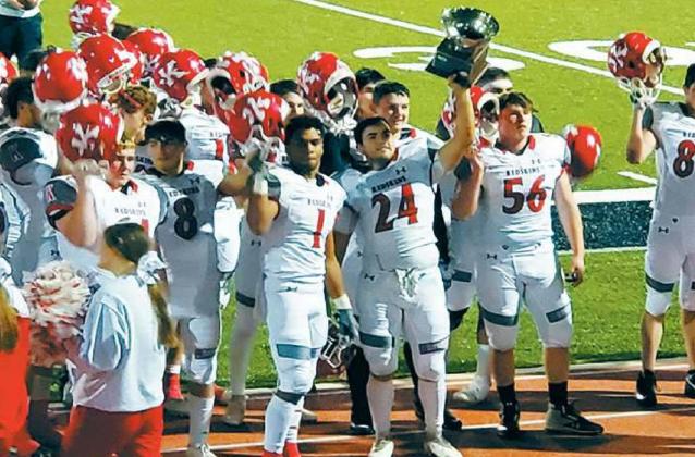 Kingston’s A.J. McKinney (#24) hoists the Marshall County Super Bowl trophy as the Redskins sing their fight song after the game. Michael Haggerty