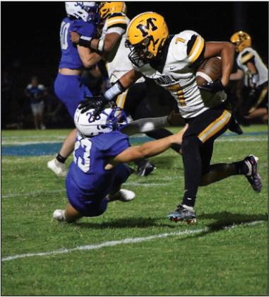 Uziel Flores runs the ball down the field while fighting off his opponent. Jennifer Rushing