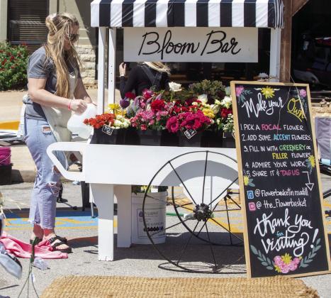 Melissa Cargal of the Flower Basket arranges flowers on the vendor cart. Photo by Matt Swearengin