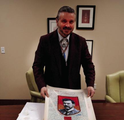 Acclaimed Chickasaw artist Dustin Mater is shown with a few of his ledger paper portraits commissioned by Vanderbilt University to honor 12 Chickasaw and Cherokee students who fought for admission to the university in the 1800s. Courtesy photo