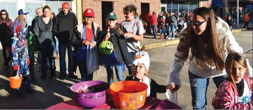 Matt Caban • The Madill Record More than 1,000 trick-or-treaters and their families descended upon Madill’s Square for the first annual Trick-or-Treat on the Square on Oct. 31. Above a group of trick-or-treaters visit the Madill Record’s for some treats.