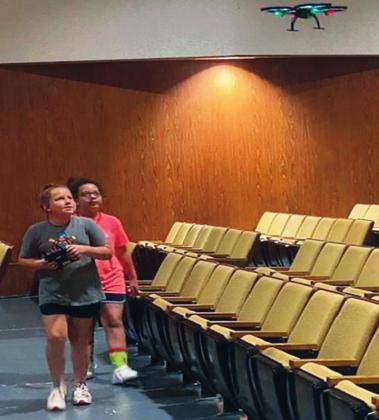 Isabella Minton and Aubrey Foster learn to fly a drone in the auditorium during one of the Wildcat University activities. Courtesy photo