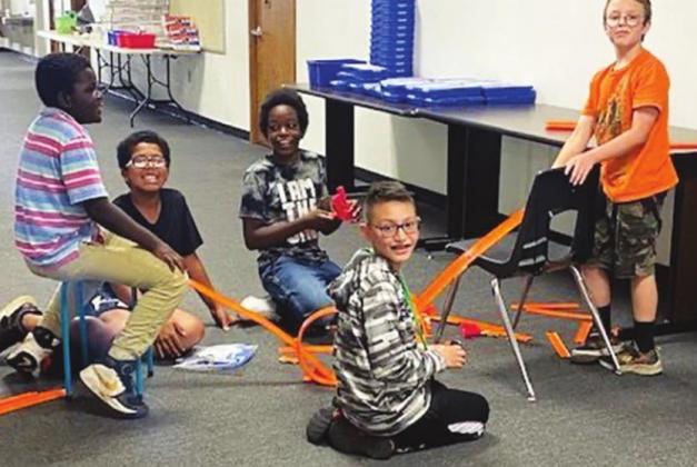 Trevor Brown, Malachi Wilson, Kedrick Fields, Azaeel Rivera, and John Bishop use a Hot Wheels Speedometry kit to learn about concepts such as energy, force and motion. Courtesy photo
