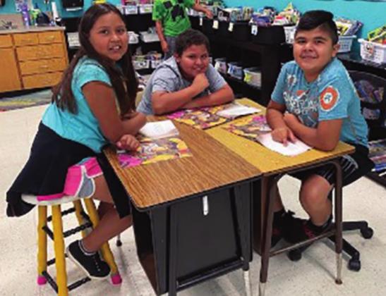 Camila Olvera, Keagan Rodriguez, and Victor Hernandez read a book together in Mrs. Beach’s summer class. Courtesy photo