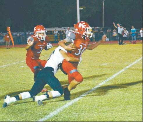 Lori Robinson • The Madill Record Redskin Damon Rowe powers forward dragging a Hugo Buffalo along, as Jarron ‘Boomer’ Morgan comes into to lend a hand during Kingston’s season opening home game last Friday.