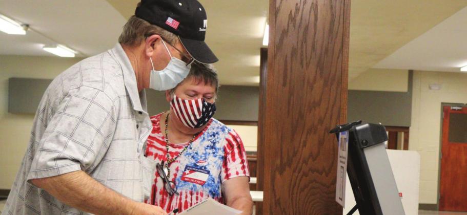 Kaylea Hutson-Miller • Oklahoma Watch Ottawa County precinct worker Kay Boman Harvey helps Ronnie Barnes feed his ballots into the voting machine Tuesday, June 30, 2020 at the Miami Civic Center.