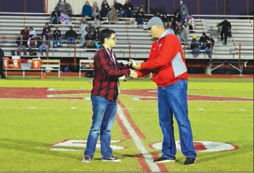 Treassie Allen • Kingston High School Yearbook Madill Record managing editor Matt Caban (left) hands Kingston Public Schools athletic director Taylor Weibner (right) a $1,000 donation to the KPS Athletic Department on behalf of the Madill Record ahead of Kingston’s Oct. 11 game against Coalgate.