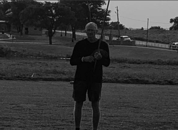Coach Al Hoppers held the American Flag at the finish line at the LCC held at Madill. Janlee Hoppers