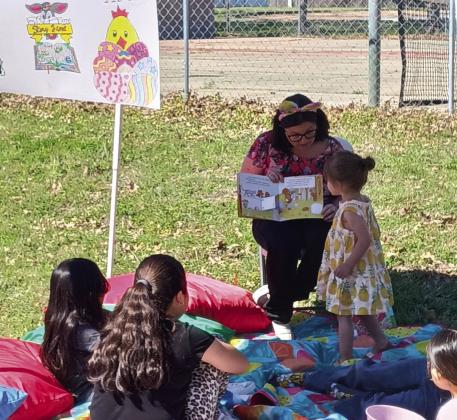 Top photo: Macy helping children with the crafts . Bottom photo: librarian Connie reading to some of the children. Courtesy photos