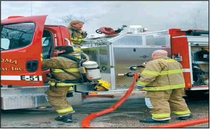 Courtesy photo TFD Fire Chief Todd Cissell, Tracy Cissell and Chris Jackson fight the fire that consumed a house on French Avenue in Woodville on New Year’s Day.