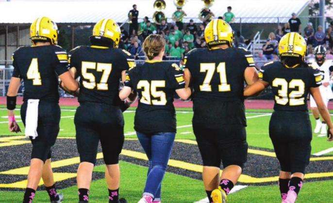 Molly Coleman, middle, takes the field with Kendall Robertson, Josh Schneider, Danny Lima, and Jimena Guevara as the honorary football captain. Summer Bryant • The Madill Record