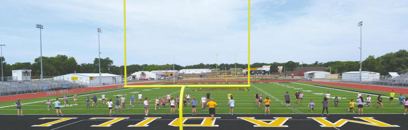 Madill athletes perform a stretching drill on the fi rst day of Madll Summer Pride June 1 at Blake Smiley Field. It was their fi rst session under new strength and conditioning coach Alex Rainwater, who was hired to join the staff of first-year head football coach Chad Speer. Matt Caban • The Madill Record