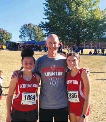 Courtesy Photo Kingston freshmen Elley Holder and Mia Moores stand with Kingston head crosscountry coach Chad Rumerat the state meet in Shawnee on Oct. 26. The pair were the Lady Redskins’ lone qualifiers for state.